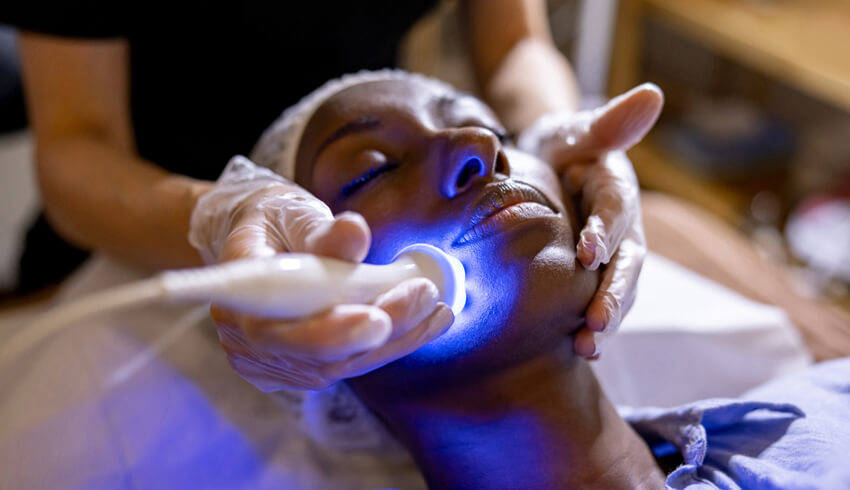 A woman receiving an ultrasound facial.